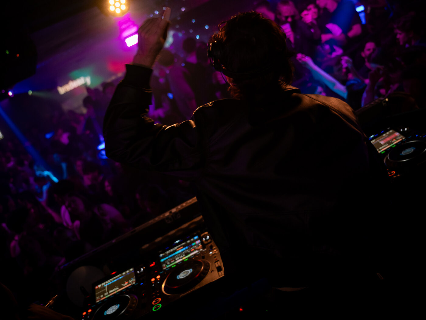 Il dj alla consolle dell'Art Cafè davanti alla sala piena