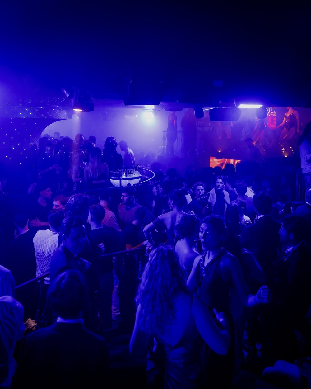 La sala dell'Art Cafè piena, in luce blu, durante una serata
